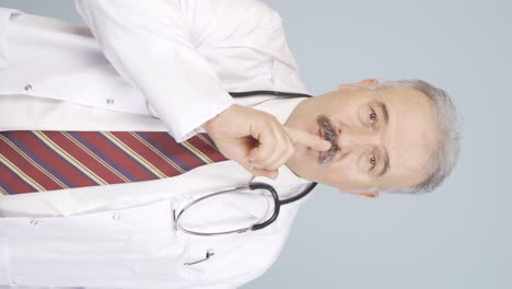 Vertical-video-of-The-old-doctor-asks-for-silence.